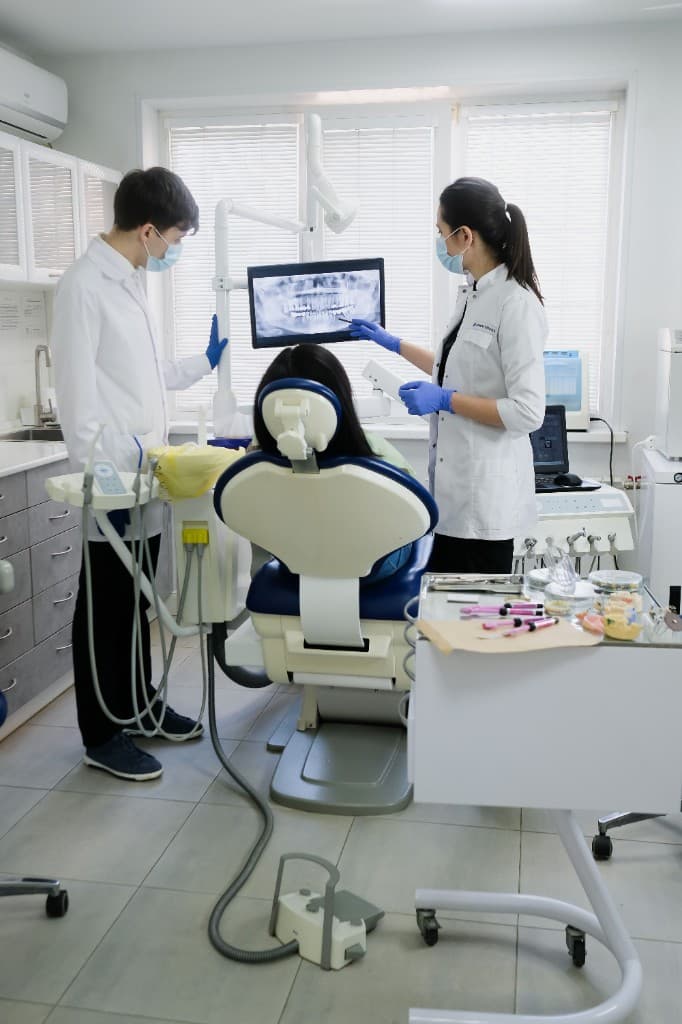 Dentists reviewing digital X-rays with a patient at Pearl Dental